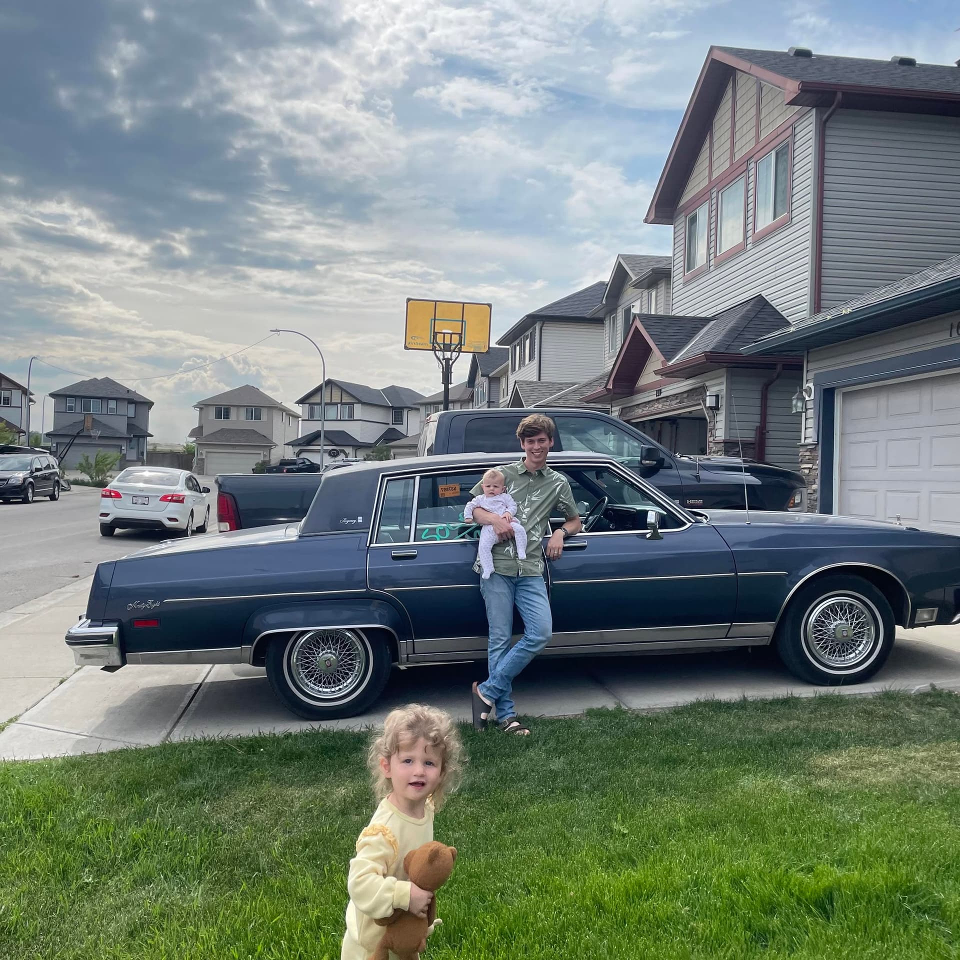Gabriel, owner of Montreal Motors YYC, with his children beside a classic car in Calgary